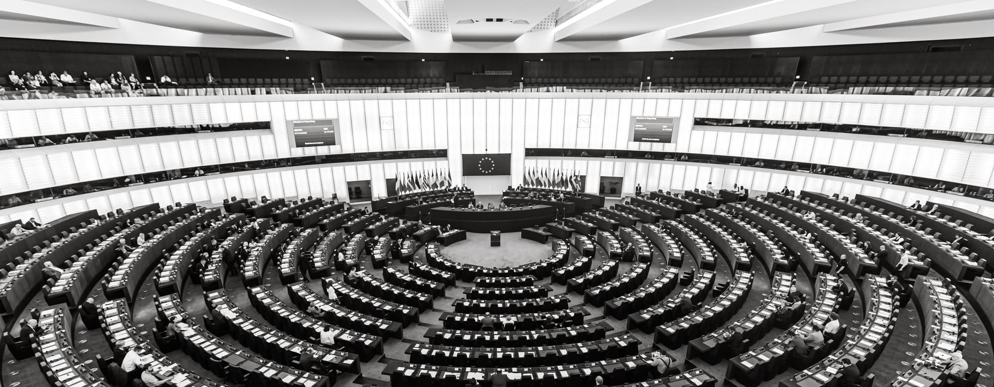 Empty plenary chamber of the European Parliament in Strasbourg with EU flags at the podium